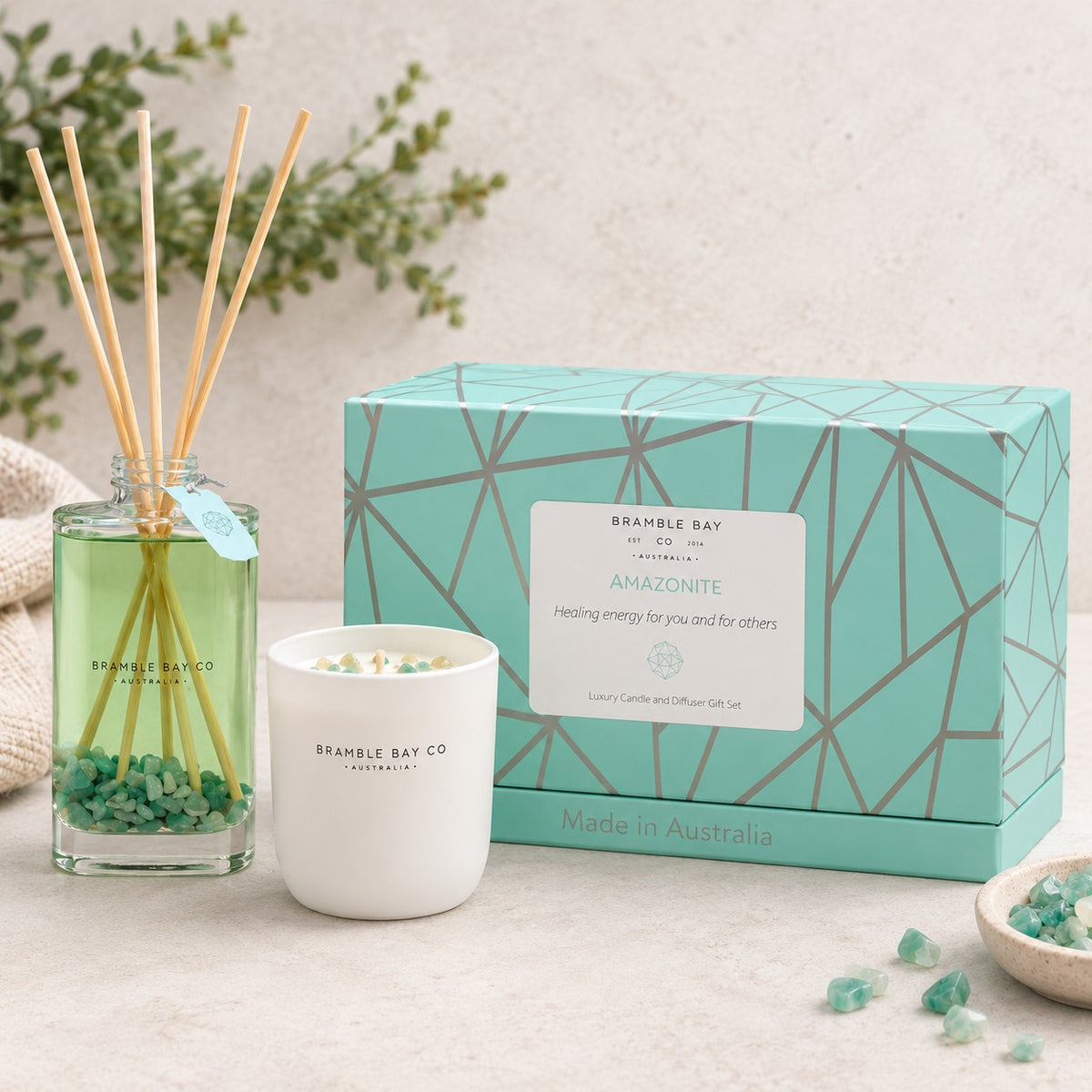 A reed diffuser and scented candle set from Brandle Bay Co in the Amazonite scent, displayed with their mint green geometric packaging box on a light stone surface.